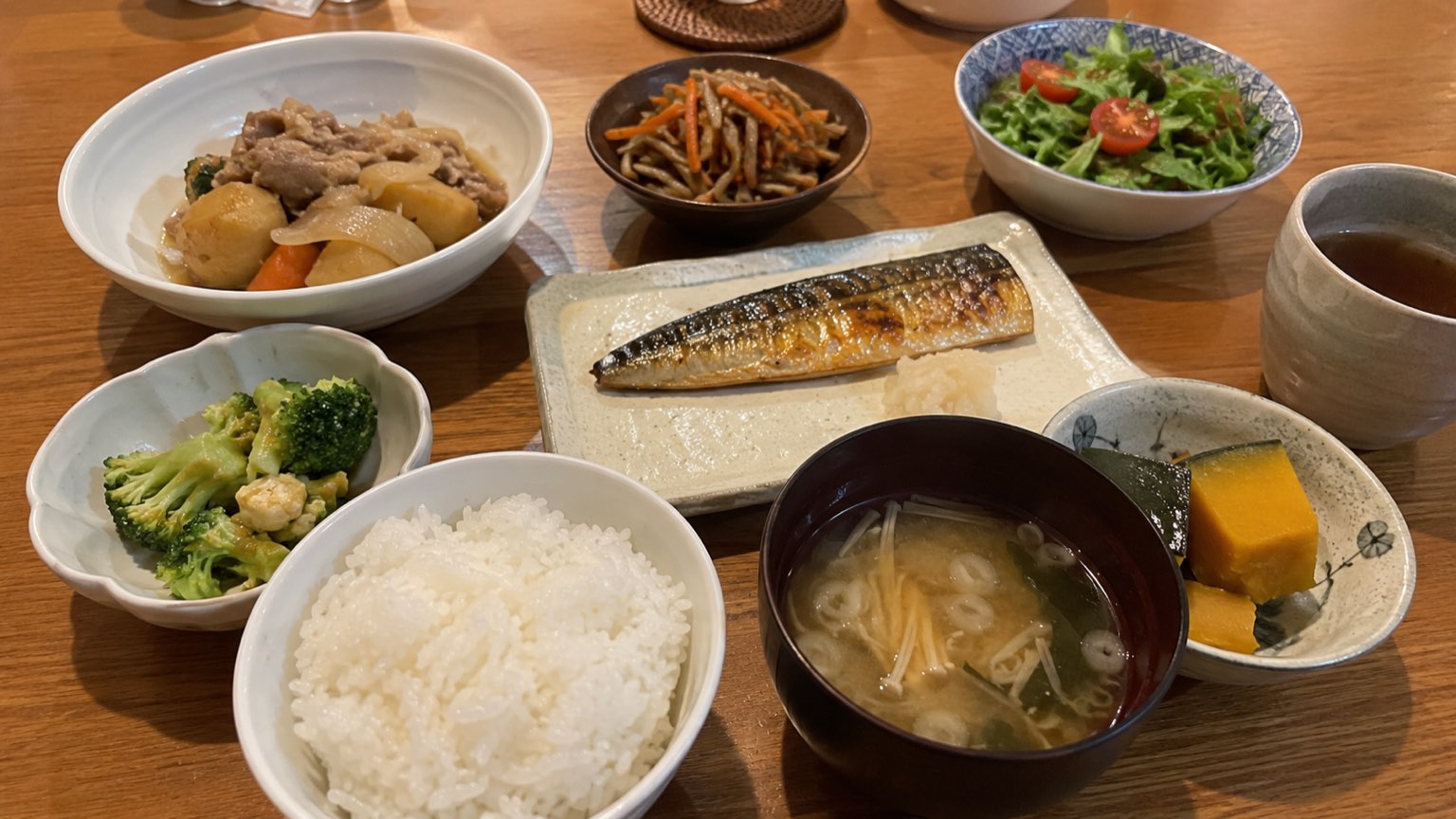 ご飯と汁物、焼き魚、煮物などが並んだ食卓